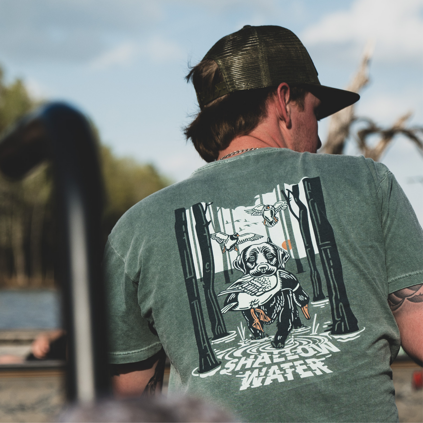 Close-up of a man wearing The Dale Tee in Blue Spruce, enjoying time on the water with the tee’s comfortable fit and relaxed style.