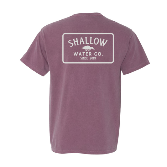 Flat lay of Berry Icon Tee with bold Shallow Water Co. logo printed on the back, displayed on a clean surface.