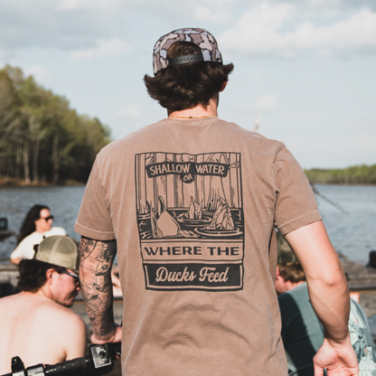 Close-up of a man wearing the Where the Ducks Feed Tee, enjoying time on the water, with a relaxed fit perfect for outdoor adventures.